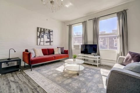 Bright, spacious living room featuring modern decor and a chic chandelier.