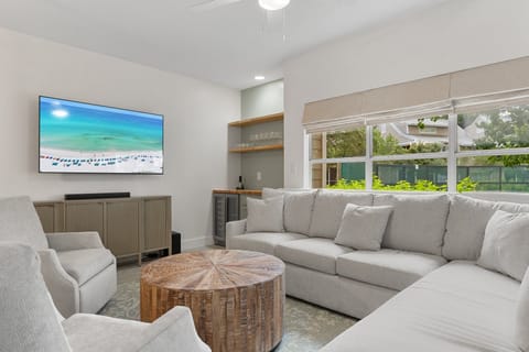 Relax in this cozy, coastal living room with plush seating, natural textures, and a built-in wine bar.