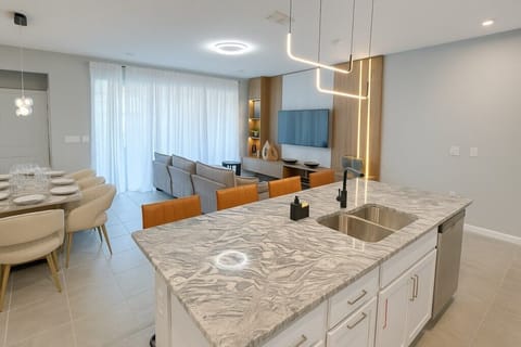 Sleek, modern kitchen with a spacious island and open-plan dining area.