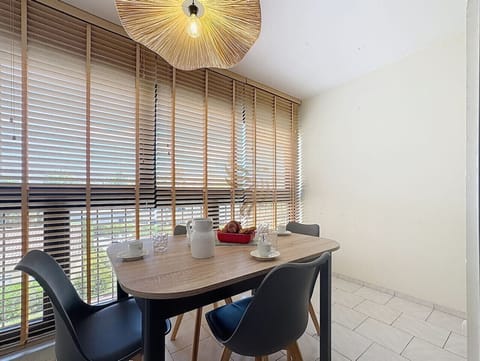 La table en bois clair accentue l`atmosphère chaleureuse. Profitez d`une lumière naturelle abondante pour des repas conviviaux autour de la table, idéale pour les petits groupes.