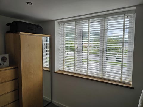 Kingsize bed with two bedside cabinets, wardrobe & views over Tan y Gopa hill. 