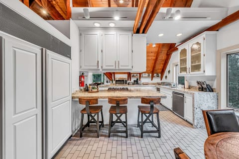 Kitchen: Stainless steel appliances, bar seating, tableware, cookware, gas range 