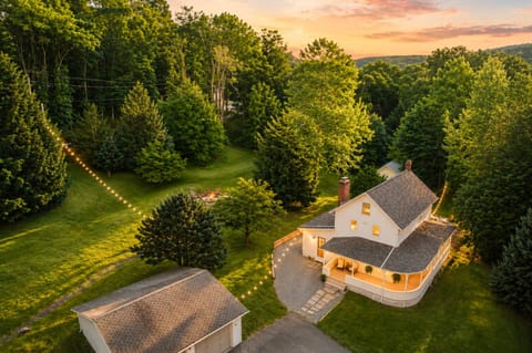 String lights guide the way from the house to the fire pit tucked under the trees. With the wraparound porch and wide open lawn, there's plenty of ground to explore before dark.