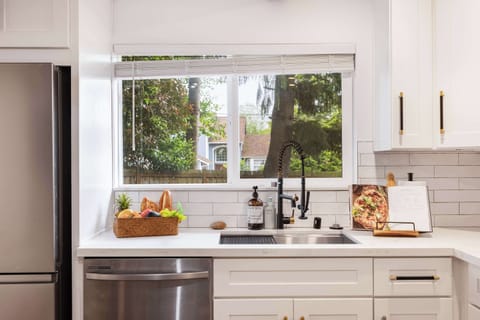 Well-equipped with a deep sink, recipe book stand, and natural light from the large window.