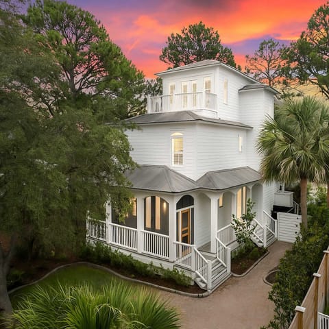Charming exterior view framed by trees, showcasing classic coastal architecture