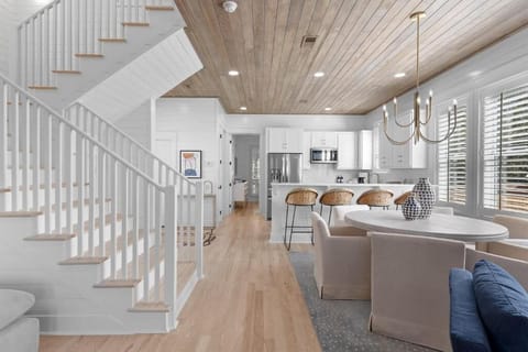 Open staircase w/ wood steps and white railings adding charm and light