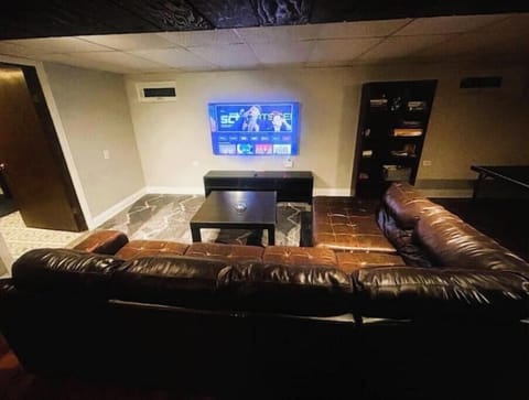 Basement with sofa, TV, and ping pong for fun.