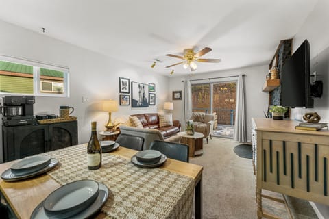 - Cozy lounge opens into a thoughtfully set dining area perfect for shared meals
- Neutral tones and soft lighting complement the scenic outdoor views beyond
- Whether entertaining or relaxing, the space flows with comfort and ease