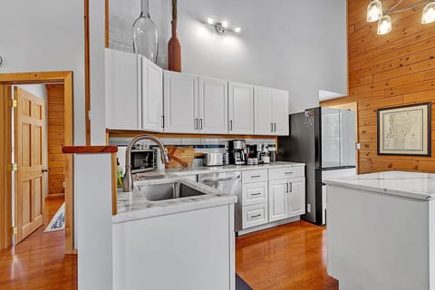 - Cook with ease in the fully equipped modern kitchen   - White cabinetry and stone countertops brighten space   - Stocked with appliances for home style meals