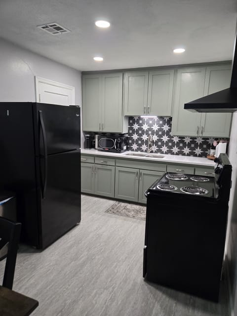 Kitchen with Refrigerator, Stove, and Vent Hood