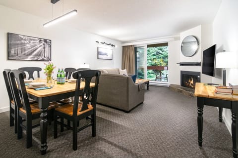 Dining for six in an open space with fireplace and private balcony with mountain views