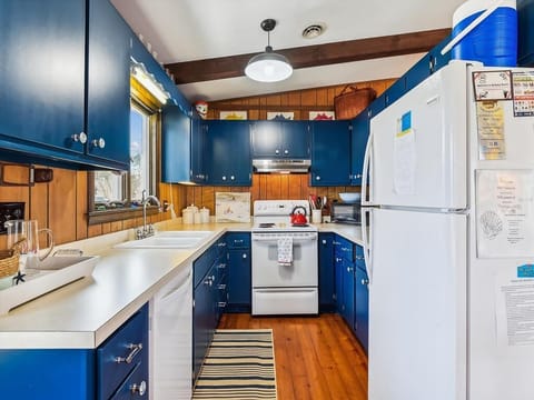 Bright and cheerful kitchen with bold blue cabinetry, full-size appliances, and plenty of prep space.