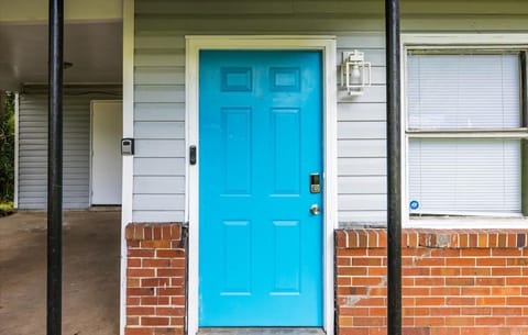 Corner house with a carport and a blue door