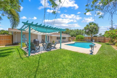 Relax by the private pool under a shaded pergola in this inviting backyard.