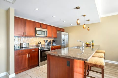 Sleek island kitchen with granite counters, pendant lights, and charm. HKK-229