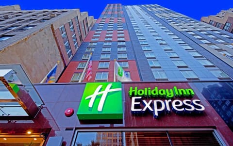 Upward view of tall Holiday Inn Express building and flags