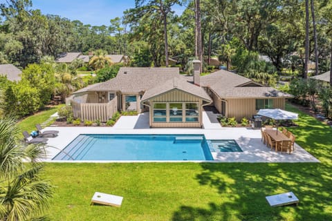 Backyard featuring a private pool, hot tub, outdoor furniture, gas grill, and a outdoor shower.