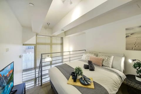 The bedroom area with a queen sized bed & plush pillows.