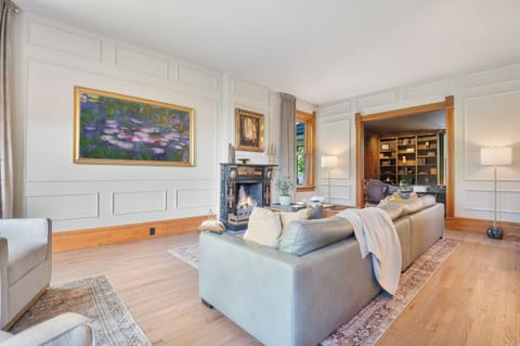 The massive parlor room with casement windows, gas fireplace, huge TV that serves as an art piece when not in use and oversized sofa with sitting area