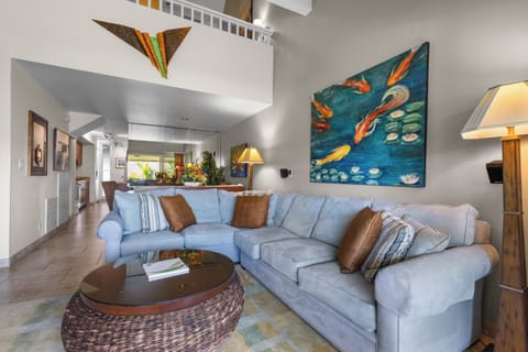 Sink into plush seating beneath soaring ceilings adorned with vibrant artwork. This open living space invites you to unwind in comfort and style.