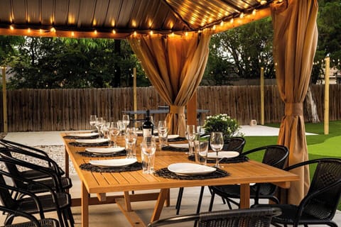 Outdoor Dining Oasis: Enjoy al fresco meals under twinkling lights and vibrant greenery!