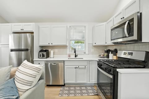 Fully equipped kitchen featuring stainless steel appliances, a gas range, microwave, dishwasher, and modern coffee & tea station—perfect for home-cooked meals or quick bites while visiting Valpo. Bright, clean, and ready for your stay!