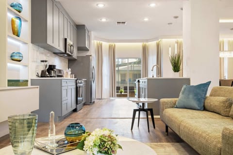 Chic gray kitchen opens to a bright lounge with stunning built-in shelves.