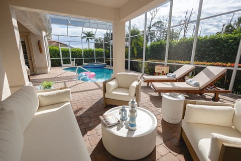 Cozy covered terrace with plush seating and relaxing poolside views.