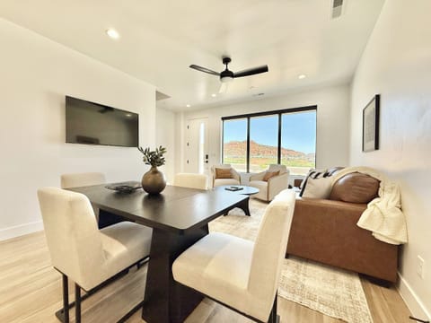 Stylish open-concept living in this Kanab, UT townhome, featuring a spacious dining area, comfortable seating, and stunning red rock views.