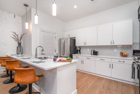 Unit 1: Fully equipped kitchen featuring stainless steel appliances, open counter space, and bar seating for 4 guests.