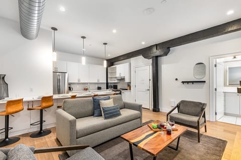 Unit 1: Open-concept living area featuring cozy furnishings, smart TV, and a sleeper sofa. (4th Floor)