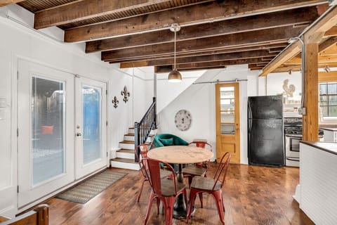 Small dining table off of kitchen, doors leading to backyard to the left, stairs leading to 2nd floor in the background