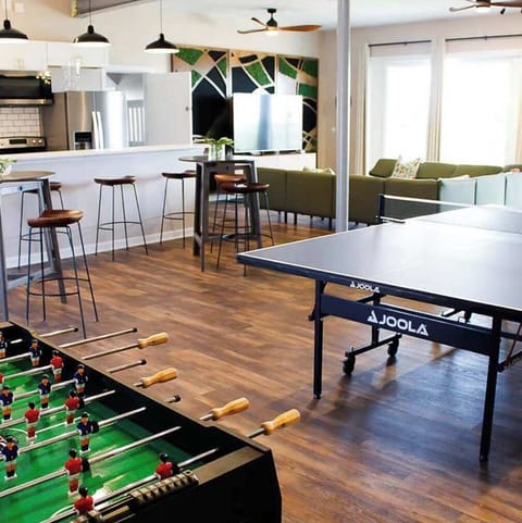 Family area which features living room, dining area, kitchen island with chairs, full kitchen, ping pong table