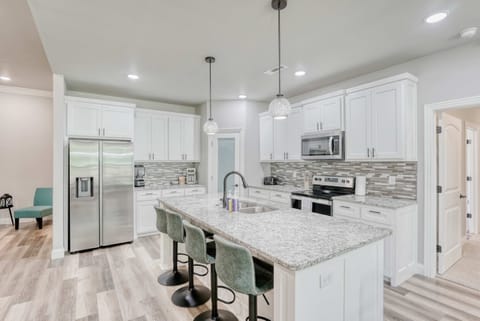 Modern kitchen with stainless steel appliances, granite countertops, and island seating—perfect for cooking and gathering.