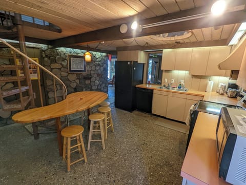 OVERVIEW:  The kitchen with all the basic cooking appliances including a dishwasher and coffeemaker along with a wooden table and stools