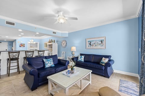Relax in this coastal-inspired living room with comfortable navy sofas and soft blue walls.