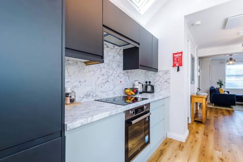 This sleek grey kitchen, featuring a stained glass door and access to the yard, is fully equipped with everything you need to cook comfortably away from home. A stylish and practical space for enjoying home-cooked meals during your stay.