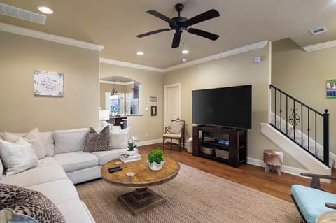 Large, open family room with new sectional sofa, chairs, and 70 inch smart TV