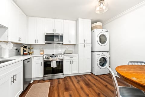 Modern kitchen with stainless appliances, in-unit laundry, and dining for four.