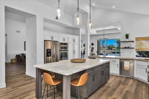 Kitchen with stainless steel French door fridge, stove, oven, microwave, dishwasher, coffee maker, and ample prep space with this beautiful countertop