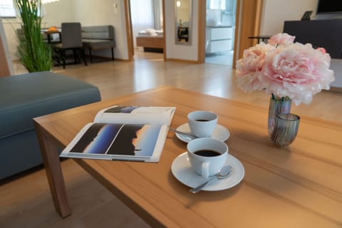 Living area with a coffee table, coffee, a magazine and a bouquet of flowers