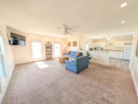Large, open living space with plenty of seating, modern decor and a large Roku Smart TV in the upstairs unit.
