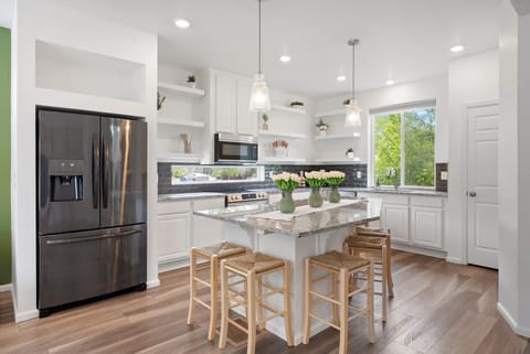 Spacious kitchen with granite island, stainless steel appliances, and seating.