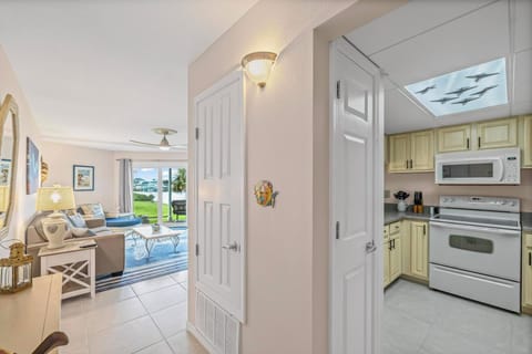 Bright kitchen with modern appliances, opening onto a cozy living area with patio access.