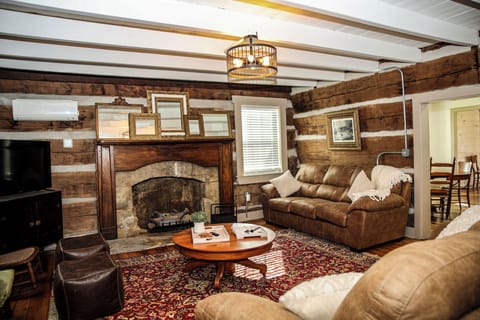 Log living room features a gas fireplace and two full couches.