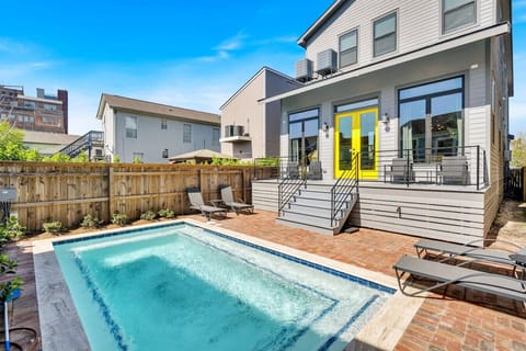 Rear exterior of home, back deck, sun loungers, and heated pool