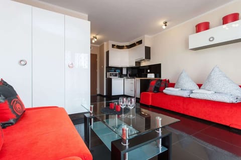 Another angle of the main room, highlighting the red theme and modern decor elements.