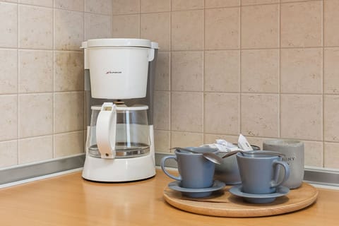 Practically equipped kitchenette with such appliances as coffee machine, fridge, kettle, and toaster.