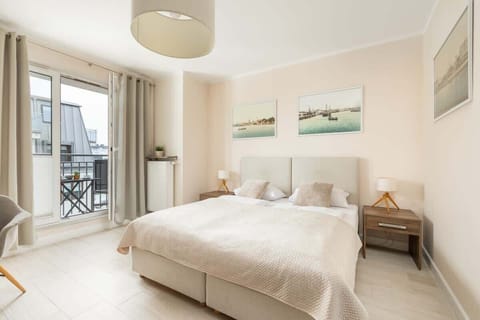 The living area features a sleek dining table and a flat-screen television.