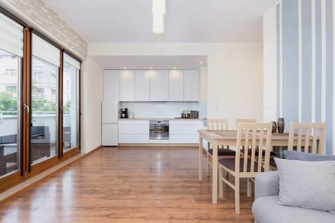 Spacious living room with kitchenette. On the left you can see the door leading to the balcony.